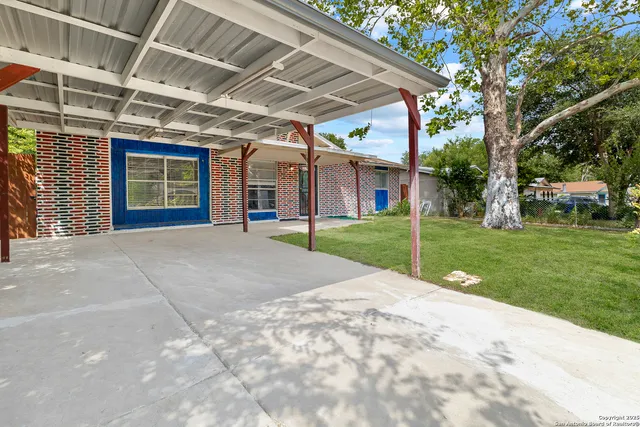 a view of a house with a big yard and potted plants