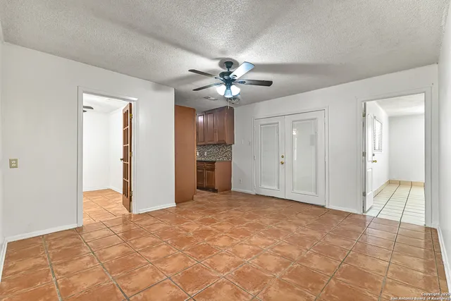 a view of a livingroom with a chandelier fan and a refrigerator