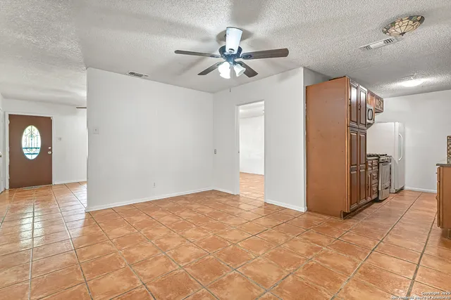 a view of a hallway with a chandelier fan and entryway