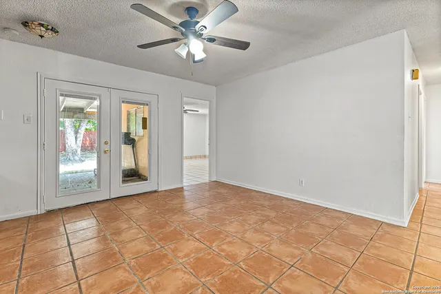 a view of an empty room with a chandelier fan