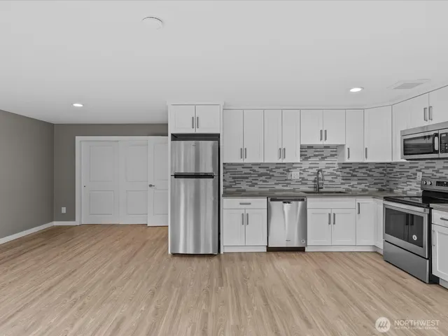 a kitchen with a refrigerator sink and cabinets