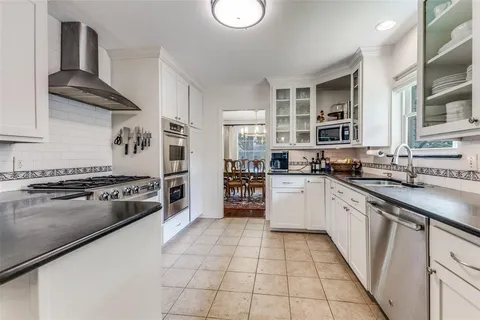 a large kitchen with stainless steel appliances granite countertop a stove and a sink