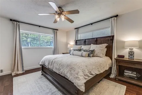 a bedroom with a bed chandelier and a large window