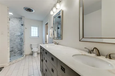 a bathroom with a granite countertop sink a toilet and a mirror