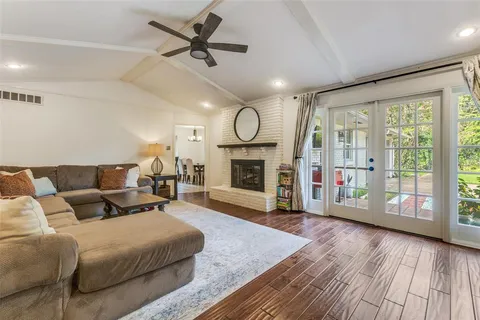 a living room with furniture a fireplace and a floor to ceiling window