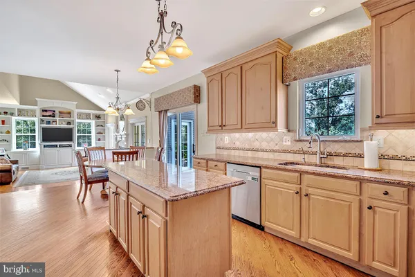 a kitchen with stainless steel appliances granite countertop a sink refrigerator stove and microwave