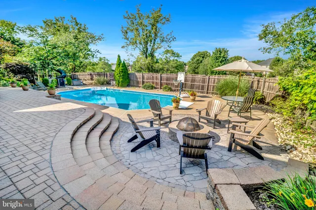 an aerial view of a house with swimming pool garden and mountain view in back