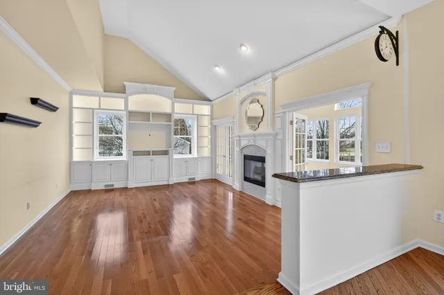 a view of empty room with wooden floor and fireplace