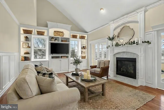 a living room with furniture a fireplace and a floor to ceiling window