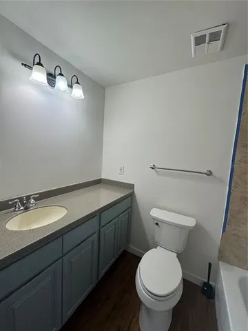 a bathroom with a granite countertop toilet and a mirror