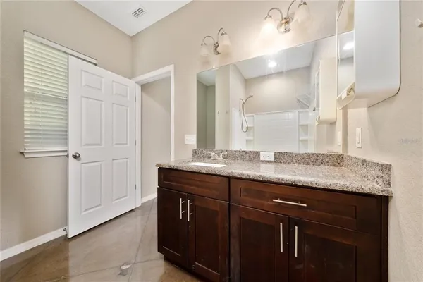 a bathroom with a granite countertop sink toilet and mirror