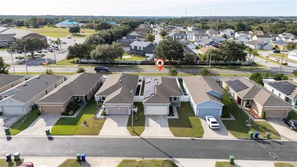 an aerial view of residential houses with outdoor space and parking