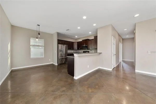 a view of kitchen with kitchen island stainless steel appliances cabinets and living room view