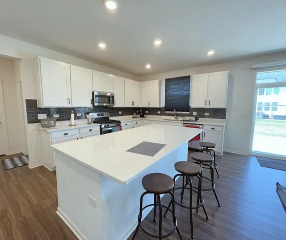 a kitchen with a dining table chairs refrigerator and cabinets