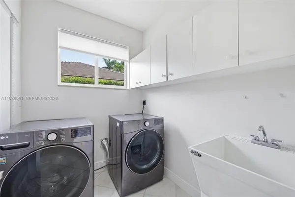 a utility room with sink dryer and washer
