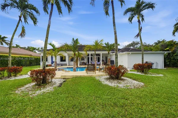 a view of a house with a yard patio and swimming pool