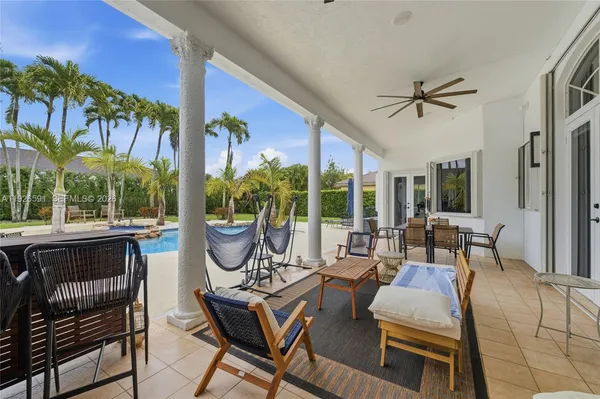 a living room with patio furniture and a potted plant