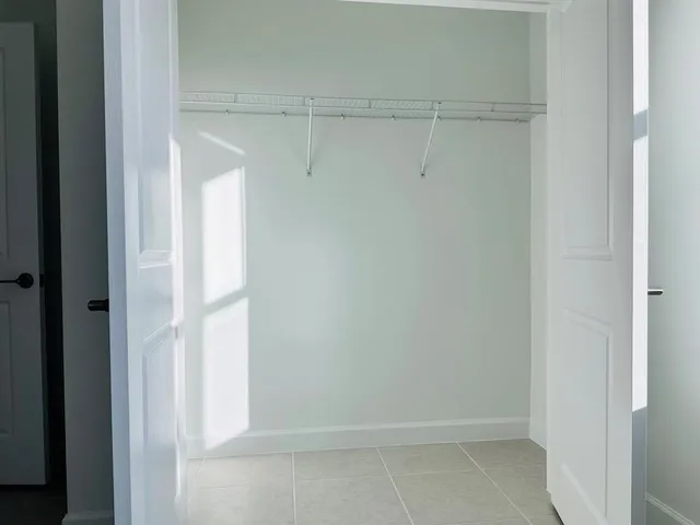 an empty room with windows and closet