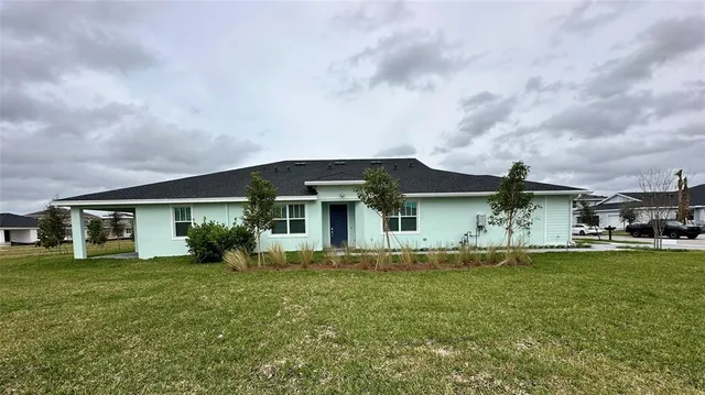 a front view of a house with a garden and trees