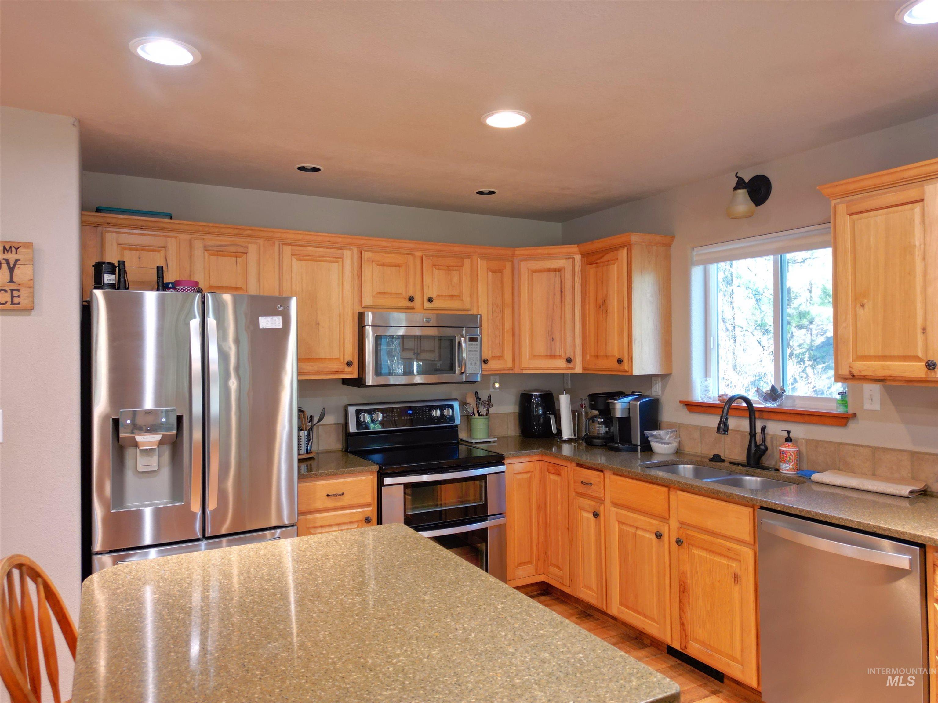 14 Forest Trail Road Garden Valley, ID 83622 - Photo 12 of 45 Kitchen featuring stainless steel appliances, recessed lighting, light wood finish cabinetry, and dark stone counters