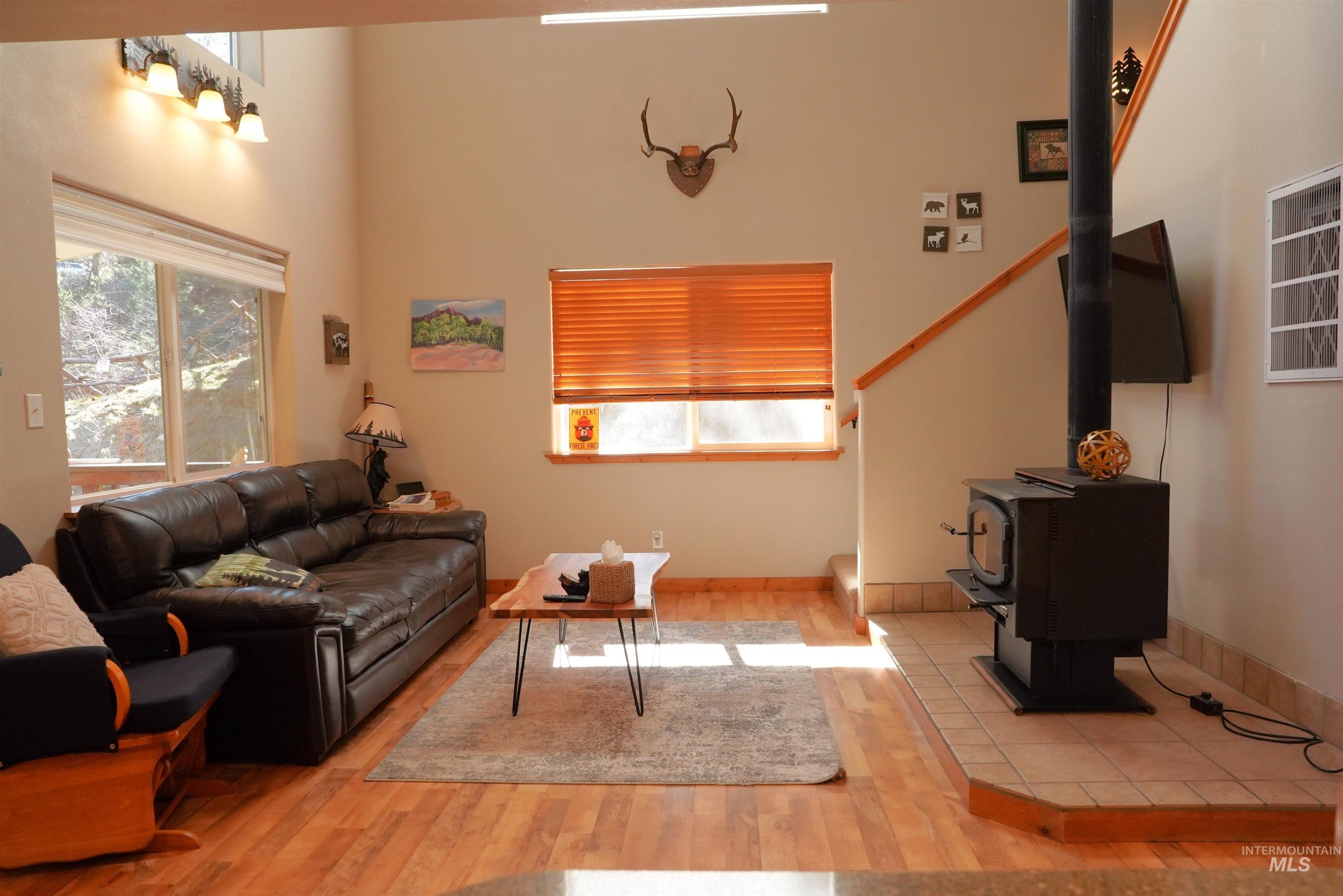 14 Forest Trail Road Garden Valley, ID 83622 - Photo 17 of 45 Living area featuring a wood stove, light wood-type flooring, and a high ceiling