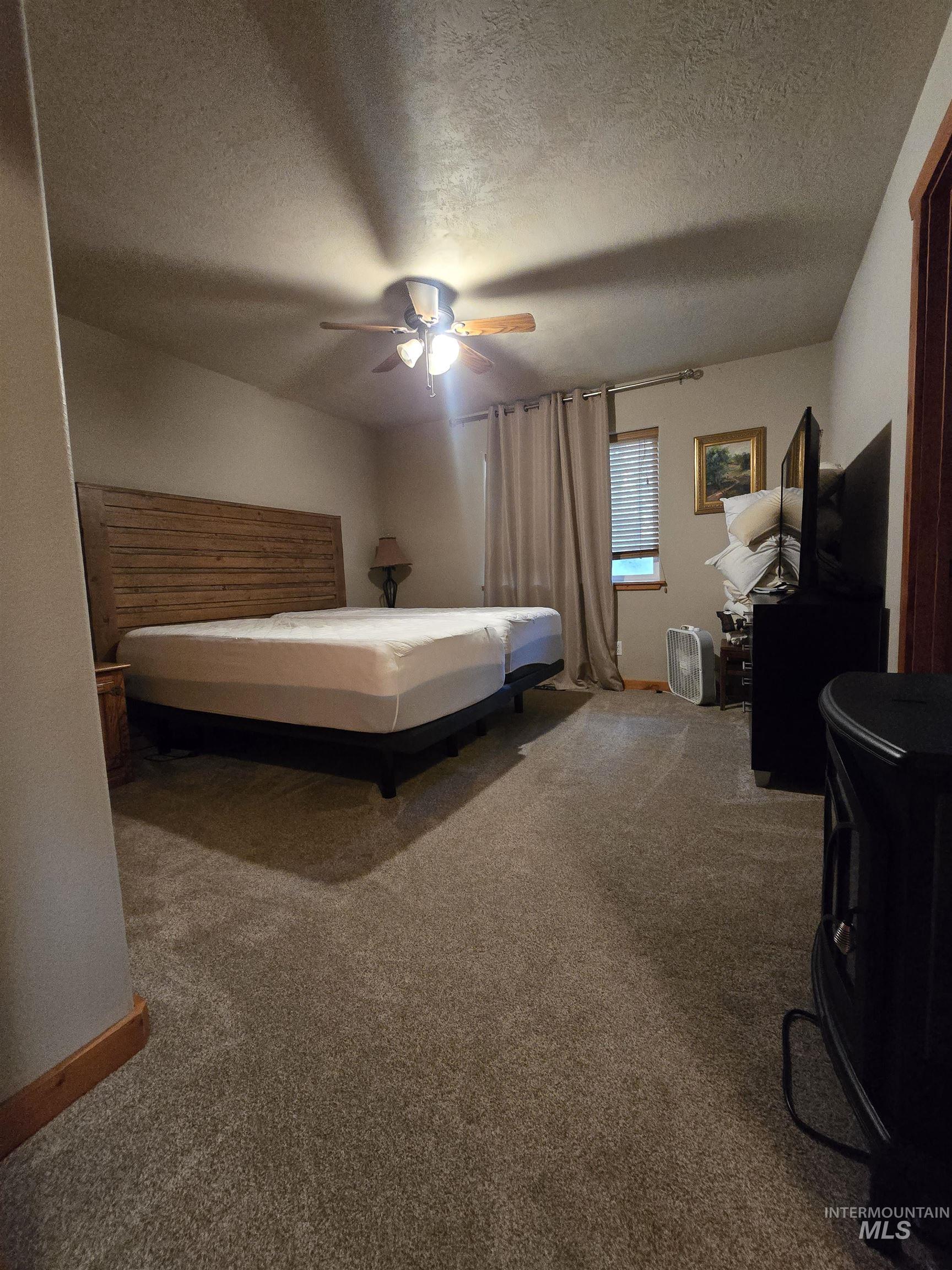 14 Forest Trail Road Garden Valley, ID 83622 - Photo 23 of 45 Bedroom with carpet floors, a textured ceiling, and ceiling fan