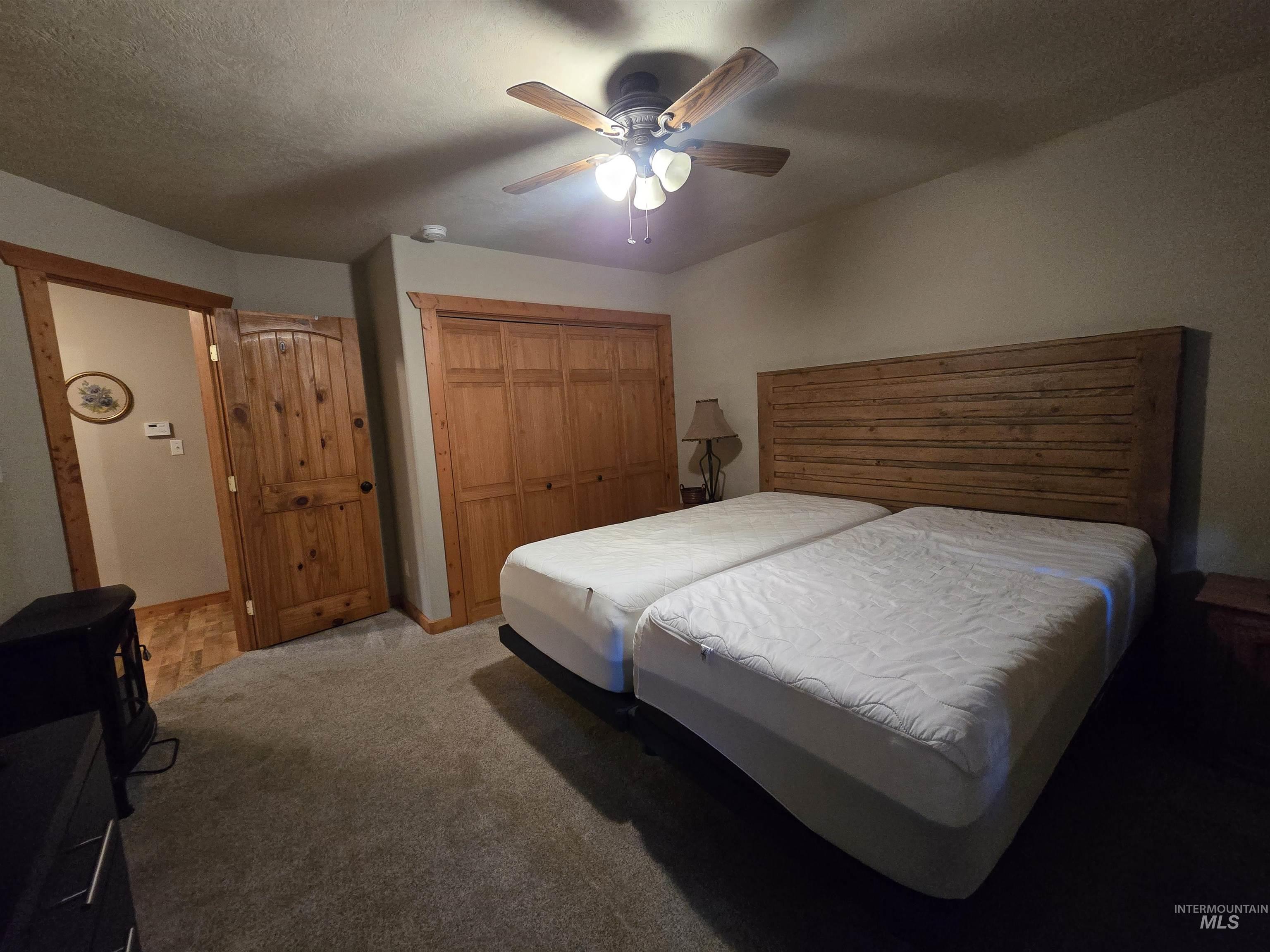 14 Forest Trail Road Garden Valley, ID 83622 - Photo 24 of 45 Bedroom with light carpet, ceiling fan, a closet, and a textured ceiling