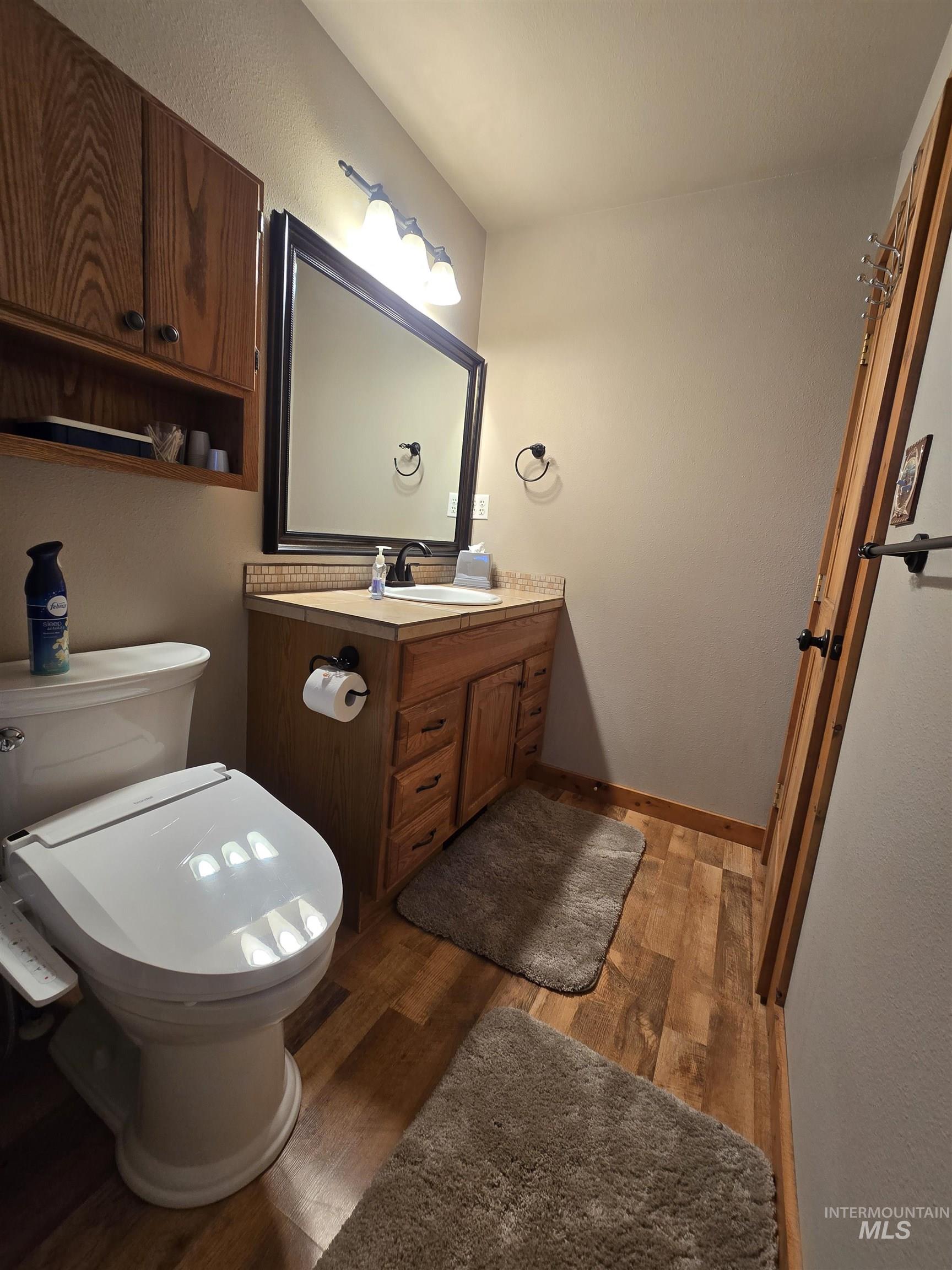 14 Forest Trail Road Garden Valley, ID 83622 - Photo 26 of 45 Half bath with vanity, dark wood-style flooring, and a textured wall