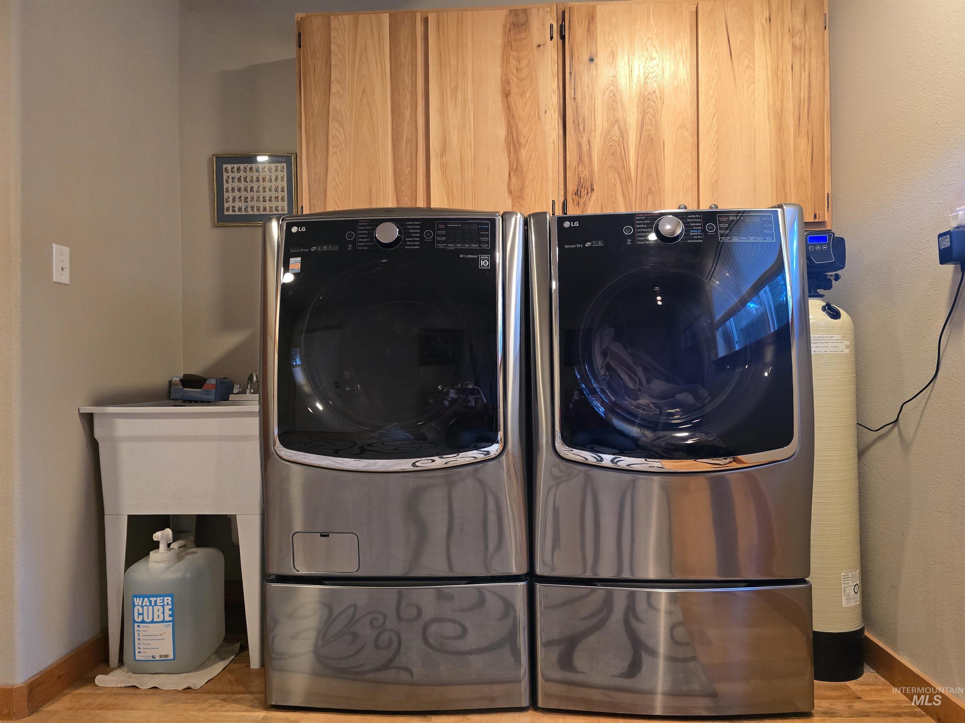 14 Forest Trail Road Garden Valley, ID 83622 - Photo 27 of 45 Laundry area featuring light wood-style flooring, washer and clothes dryer, and cabinet space