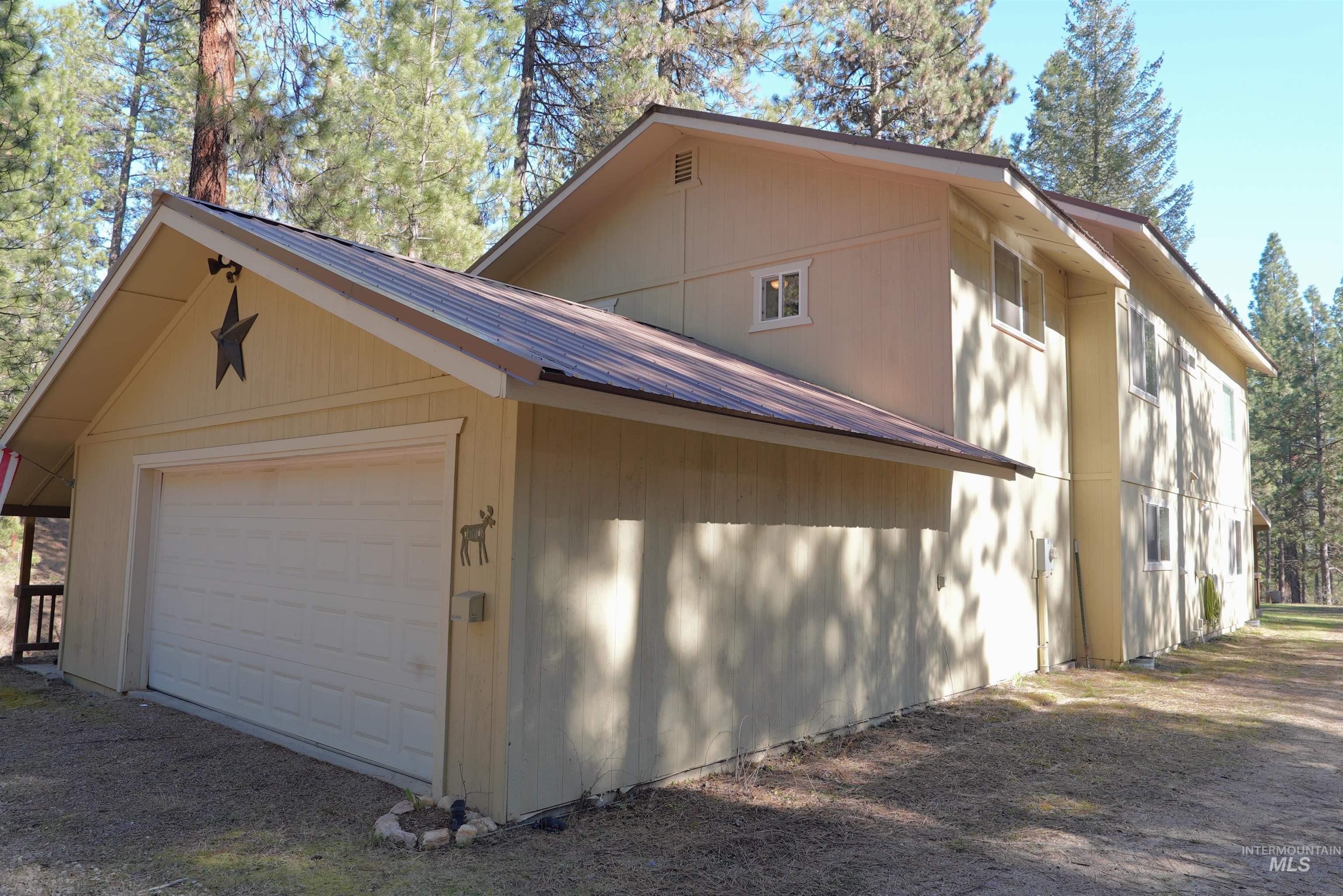 14 Forest Trail Road Garden Valley, ID 83622 - Photo 4 of 45 View of side of property featuring a metal roof, an outdoor structure, and driveway