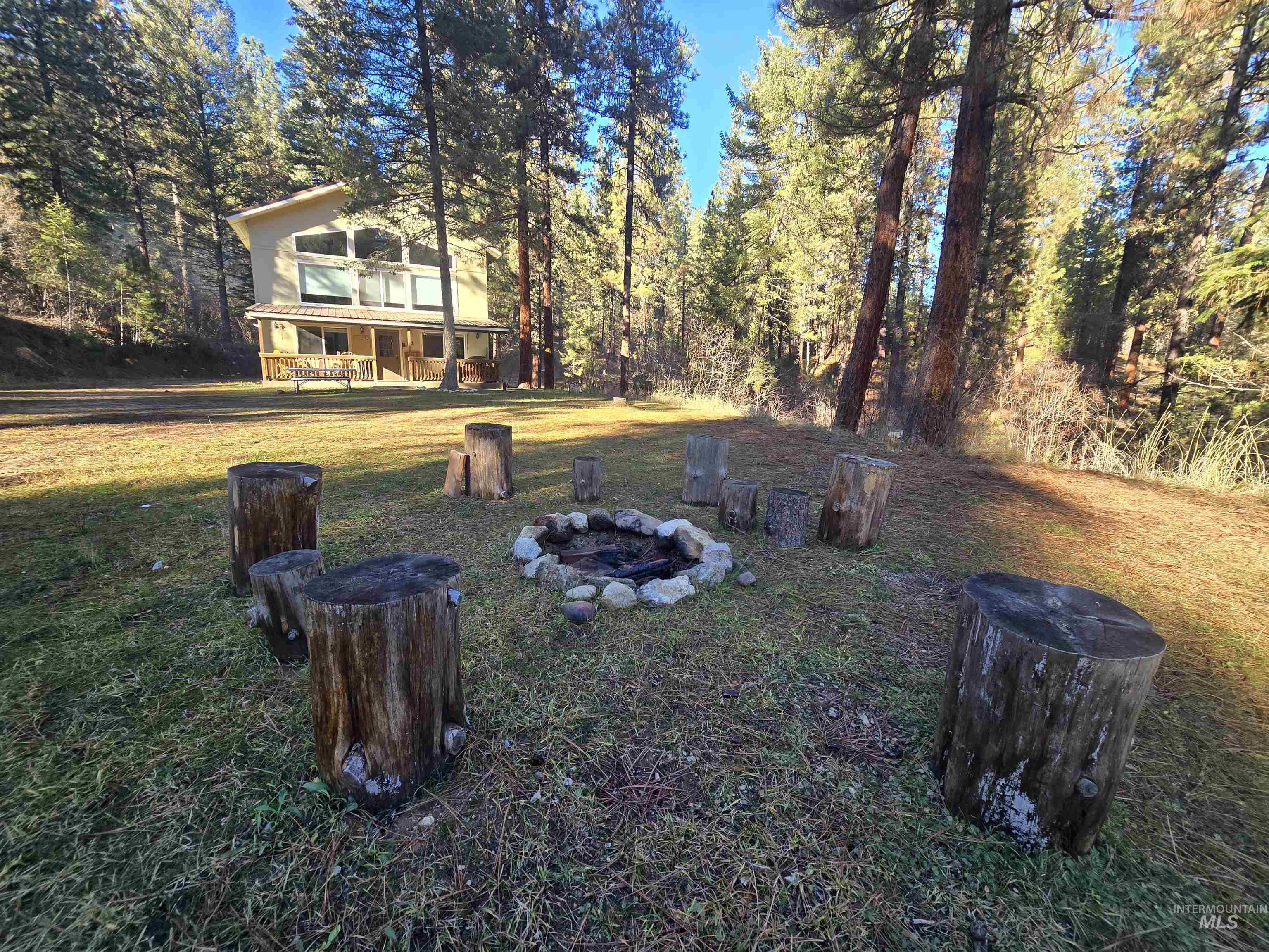 14 Forest Trail Road Garden Valley, ID 83622 - Photo 5 of 45 View of grassy yard featuring an outdoor fire pit and view of scattered trees