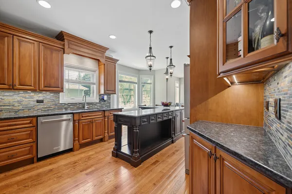 a kitchen with stainless steel appliances granite countertop a stove a sink and a refrigerator