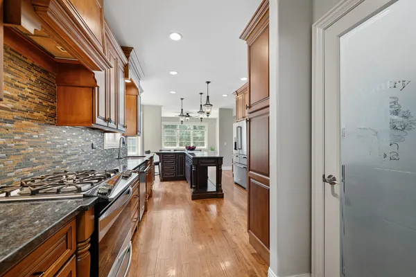 a kitchen with stainless steel appliances granite countertop a refrigerator a stove and a sink