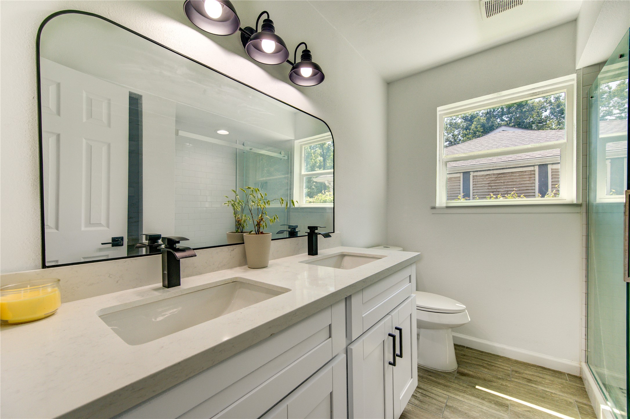 5411 Logston Lane Spring, TX 77389 - Photo 39 of 50 Modern bathroom with dual sinks, sleek fixtures, and a large mirror, complemented by natural light from a well-placed window.