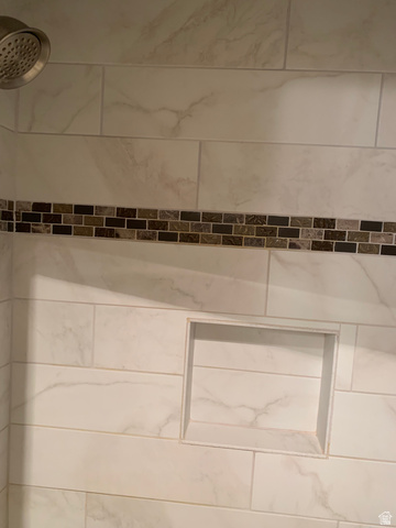 220 West Mill Road Ferron, UT 84523 - Photo 20 of 40 Shower stall featuring white marble-look subway tile, a decorative mosaic tile accent band, a built-in shower niche, and a chrome showerhead