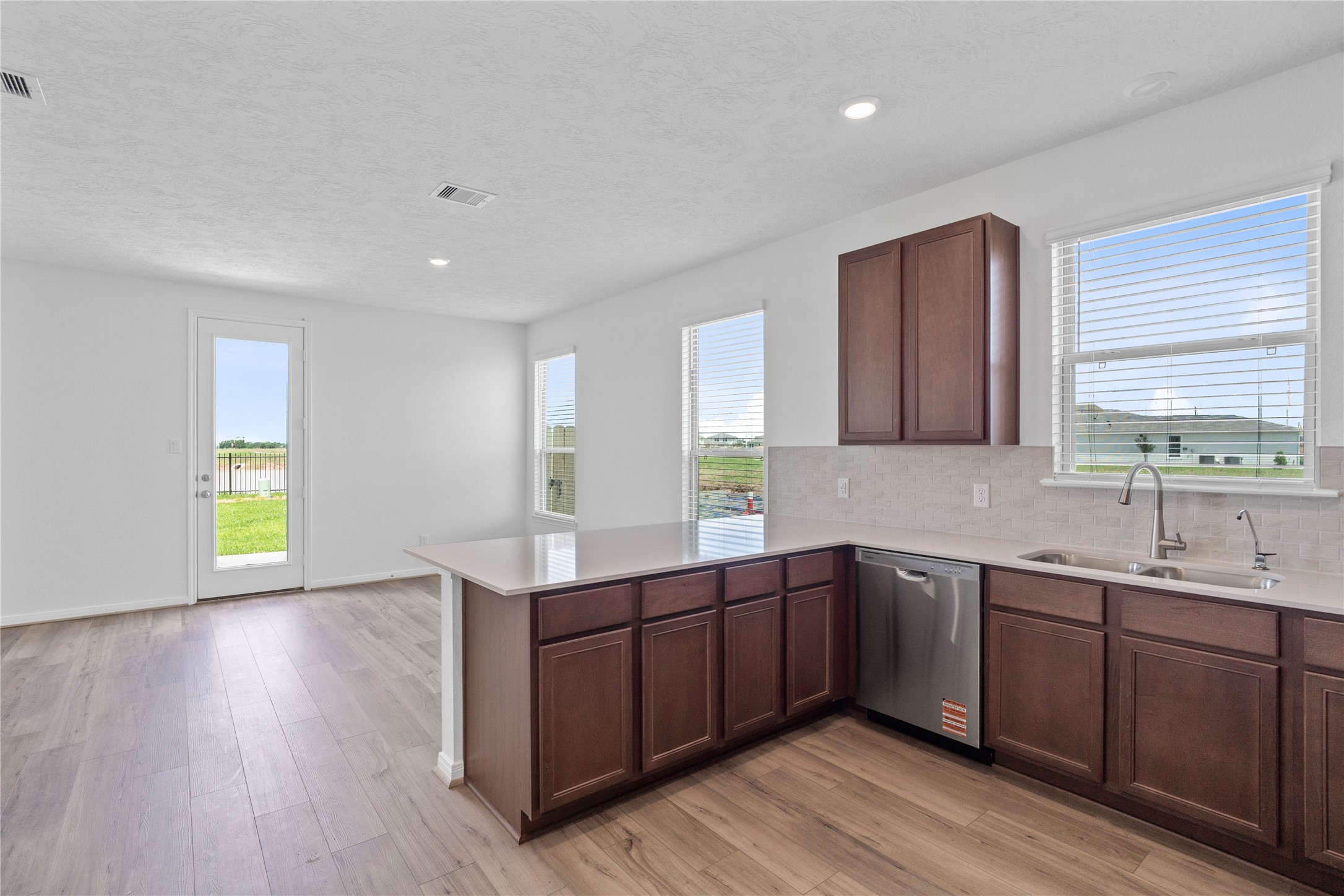 7210 Brooklea Road Beasley, TX 77417 - Photo 16 of 32 Bright kitchen featuring a sunny window over the sink, scenic backyard views, and seamless flow into the dining.