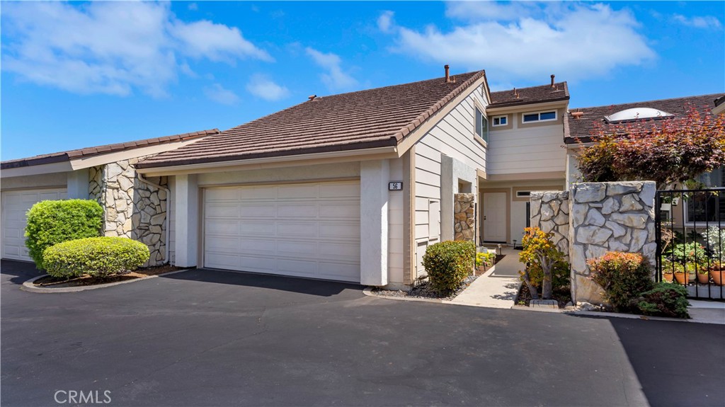 56 Wetstone, Unit 35 Irvine, CA 92604 - Photo 15 of 36 a front view of a house with a yard and garage
