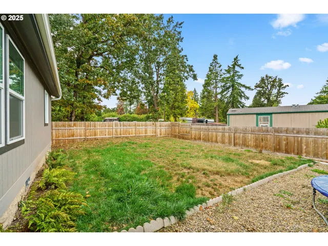 a view of backyard with wooden fence