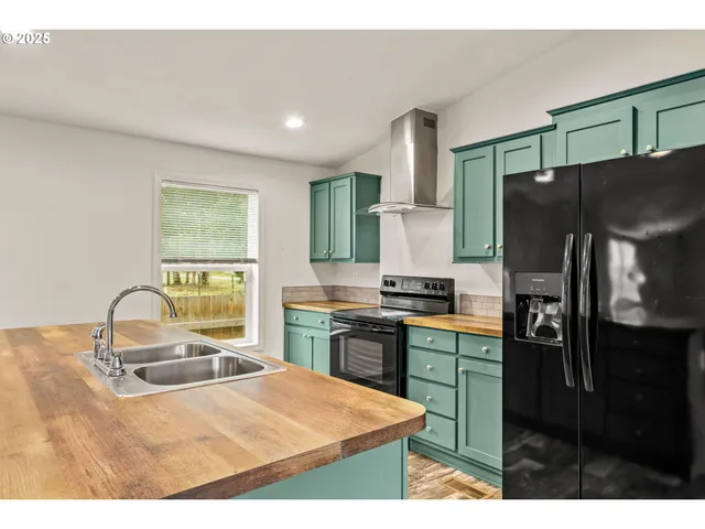 a kitchen with stainless steel appliances kitchen island granite countertop a refrigerator and a stove top oven