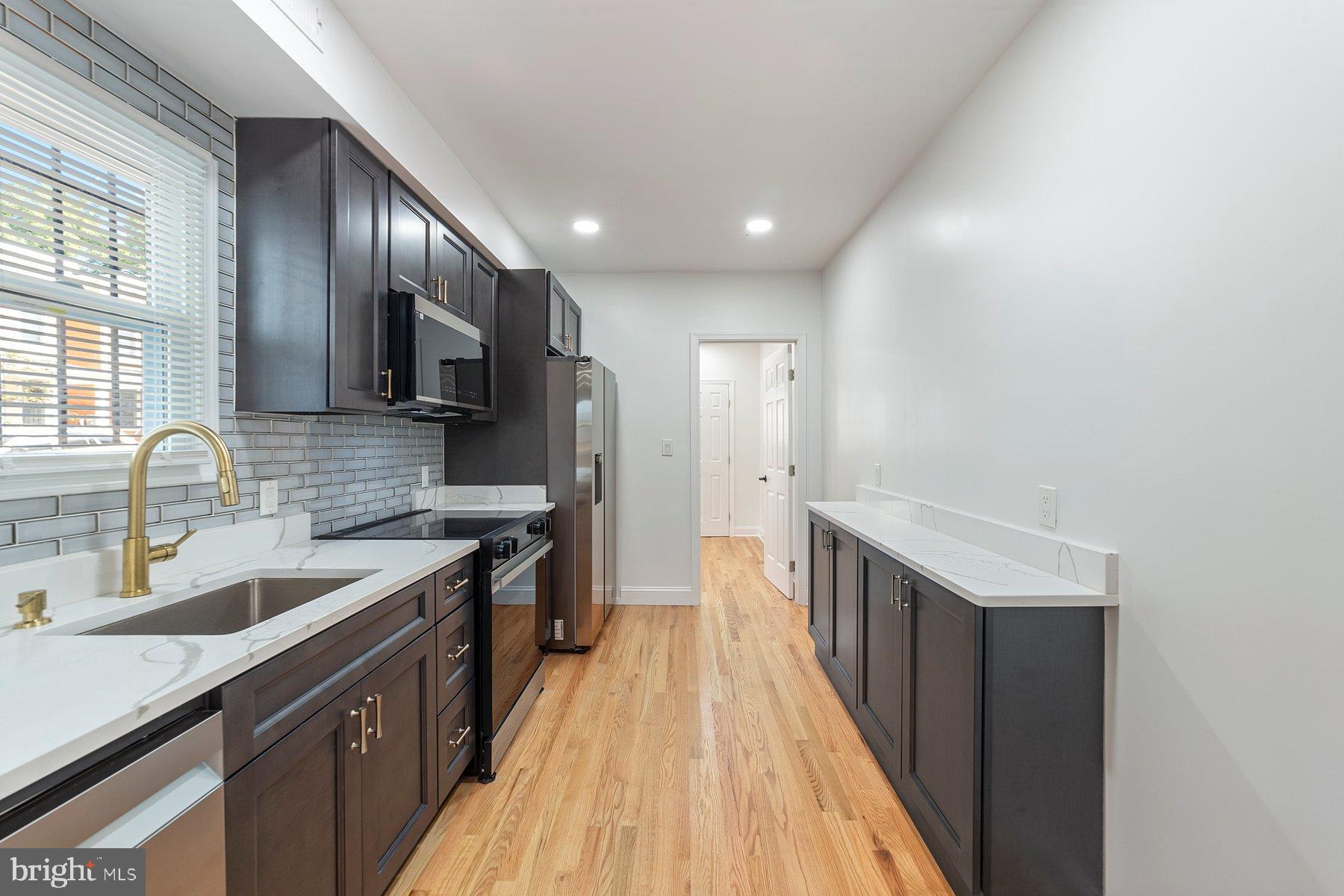 1325 W Street Southeast Washington, DC 20020 - Photo 3 of 26 a kitchen with a sink and wooden cabinets