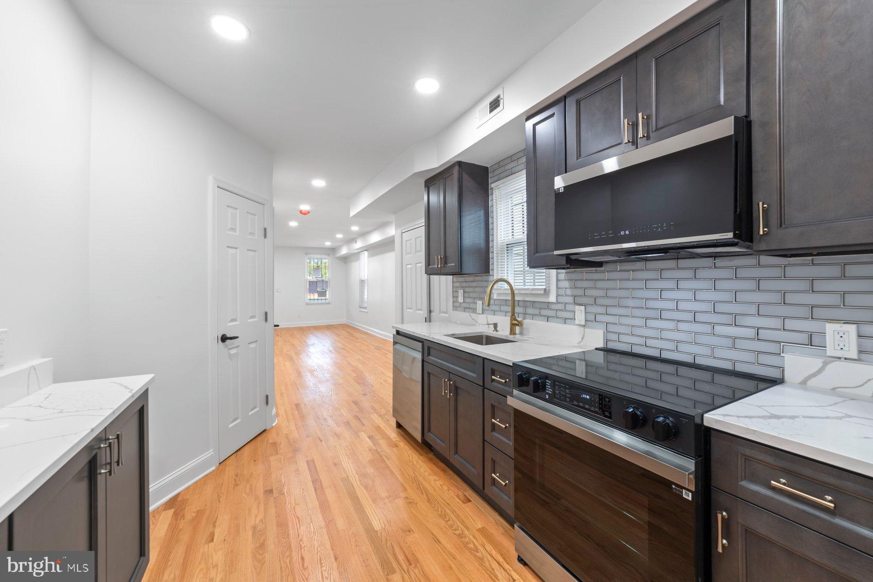 1325 W Street Southeast Washington, DC 20020 - Photo 4 of 26 a kitchen with stainless steel appliances granite countertop a sink stove and cabinets