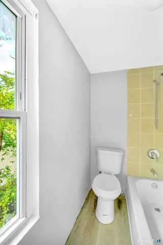 a white toilet sitting next to a bath tub