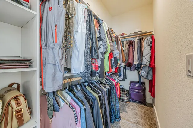 a view of walk in closet with clothes