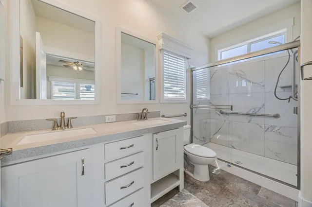 a bathroom with a granite countertop sink toilet and shower
