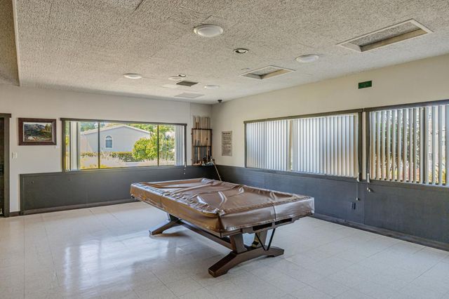 a living room with a table tennis table and windows
