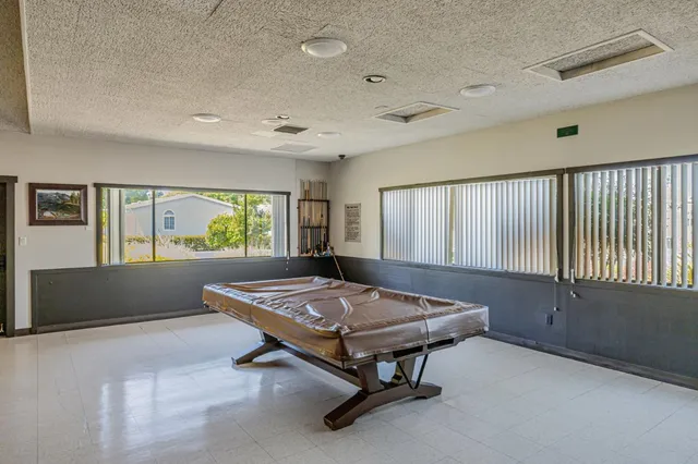 a living room with a table tennis table and windows