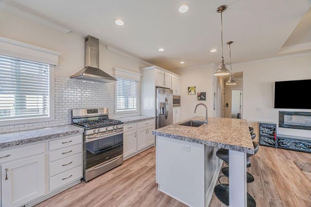 a kitchen with stainless steel appliances granite countertop a stove oven and a refrigerator