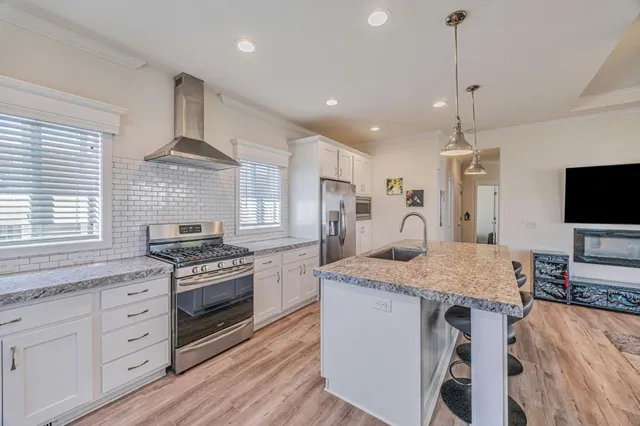 a kitchen with stainless steel appliances granite countertop a stove oven and a refrigerator
