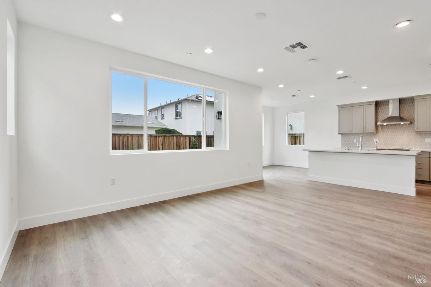 1556 Country Manor Drive Santa Rosa, CA 95403 - Photo 13 of 40 a view of an empty room with wooden floor and a kitchen