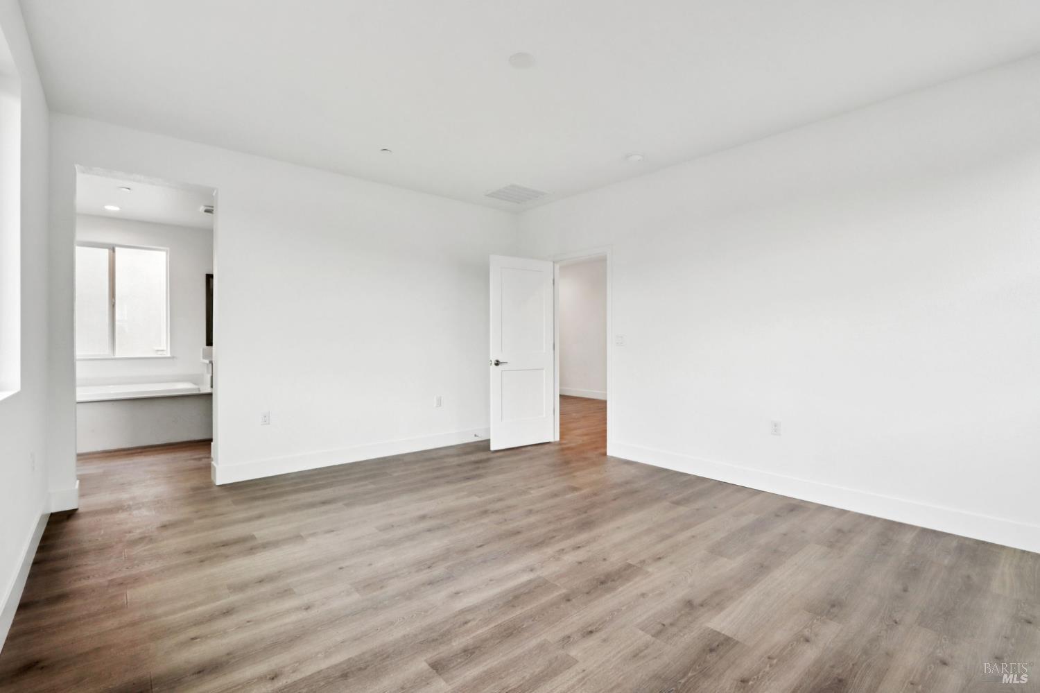 1556 Country Manor Drive Santa Rosa, CA 95403 - Photo 35 of 40 a view of an empty room with wooden floor and a window